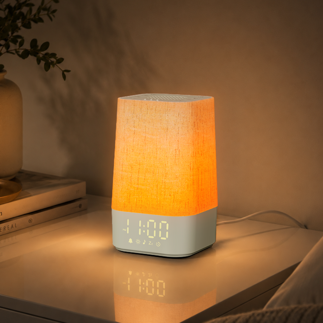 Fabric white-noise alarm clock in a softly lit bedside scene